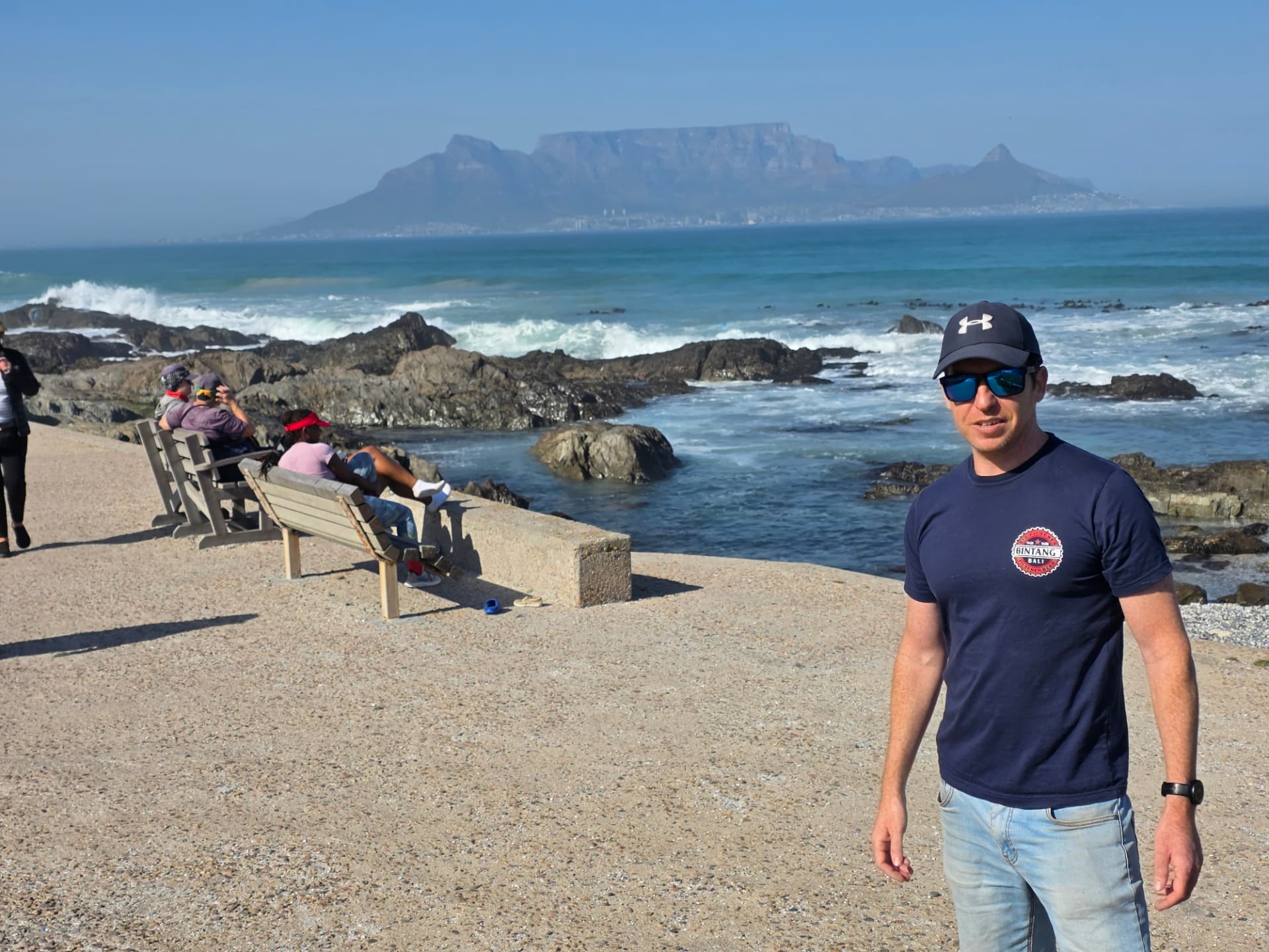Alex Sabino standing on the Cape Town sea front, with Table Mountain rising across the bay